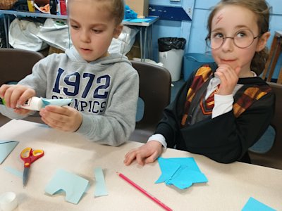 These Beavers are adding ears to their bookmarks and one is also adding a horn.