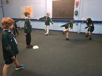 Several Cubs form barriers for the other Cubs acting as planes to navigate past, while the controllers call their phonetic alphabet callsign to signal them to fly to the other landing point.