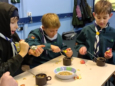 The Scouts are cutting the cores out of apples and making peanut butter & seed feeders for The Big Garden Birdwatch.