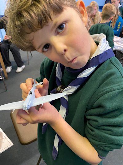 This Cub is showing off his built Spitfire model. He's done a good job.