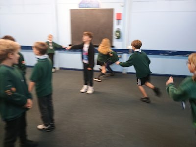 Most of the Cubs have been frozen in place, during a game of Sharks and Fishes. One Cub is running about, trying to evade capture by a Shark.