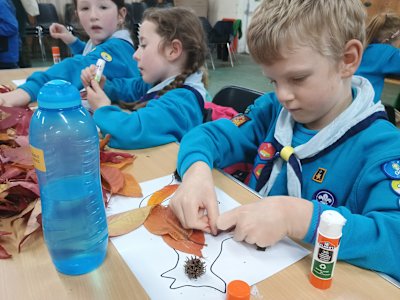 Having selected his leaves carefully, this Beaver is making sure he glues them in place just right. He's also glued an interesting spiky seed pod where the fox's eye should be.