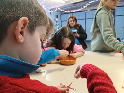 The Beavers are being extra careful while getting their beads onto their wire snowflakes. This Beaver is using a different pattern on each branch of his snowflake.