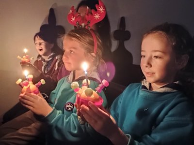 All the Christingles are lit and giving a soft glow to the Beavers' faces. 