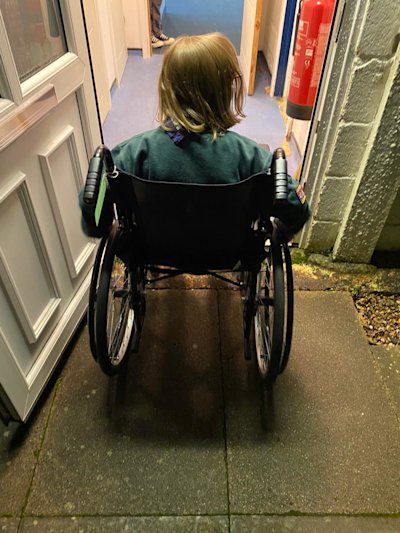 The Cubs gave the hut a test run with a wheelchair, to see how accessible it is. The Cub is trying to get over the door edge, but it's too steep.