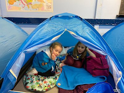 These two girls have got their tent all set up and ready for sleeping later. It looks cosy in there!