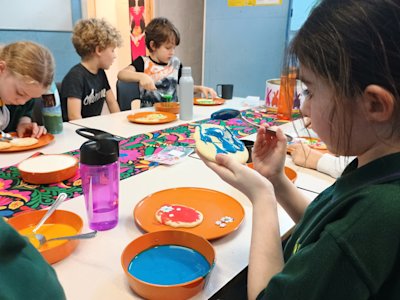 The Cubs are spreading icing onto their skull biscuits, some more carefully than others.