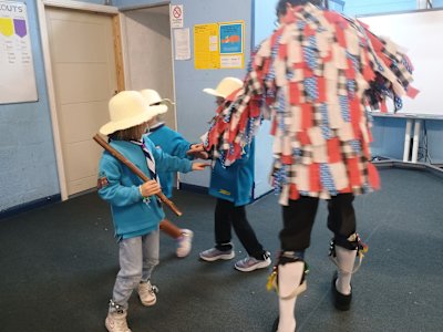 These Beavers are dancing in a circle, with their hazel sticks on their shoulders. 