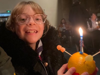 This Cub looks very happy to have her Christingle lit.