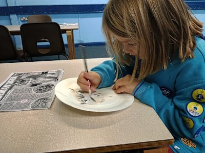 This Beaver is concentrating hard on colouring the stripes on her animal mask.