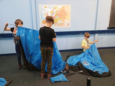 Three Cubs are carefully removing the poles from their tents.