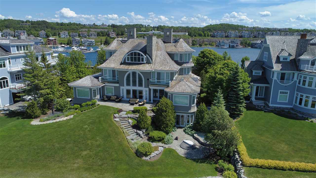 Exterior of the Bay Harbor Mansion with a lake in the background and other homes surrounding the lake.