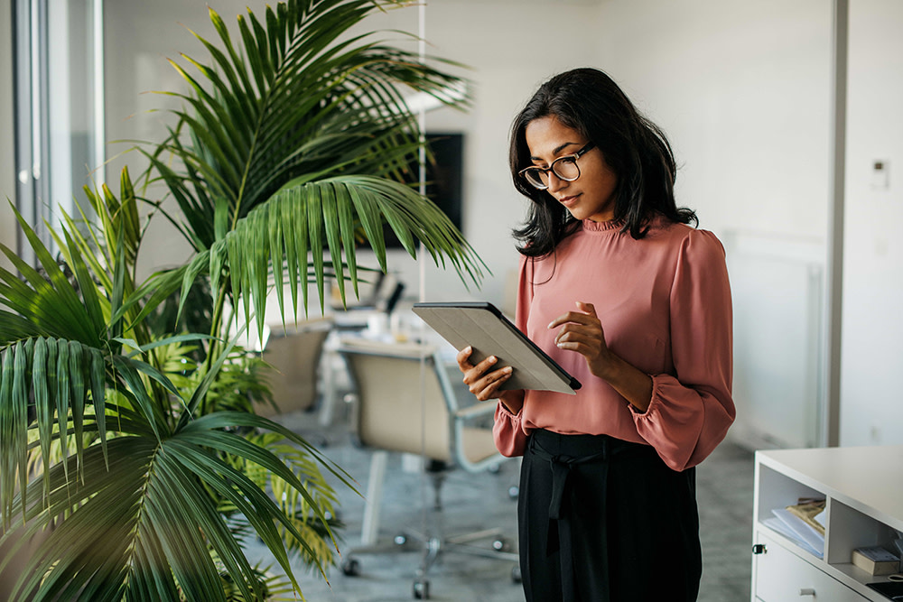 A woman holding her Ipad in an office setting. 