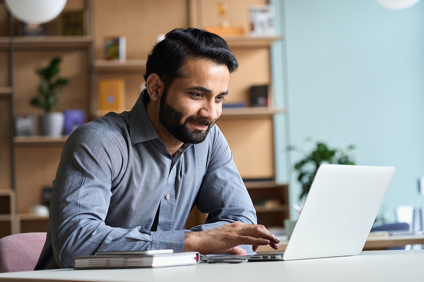 A man working on his computer smiling. 