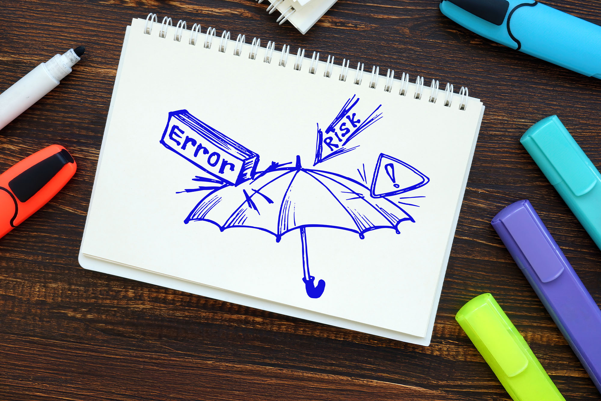 Sketch of an umbrella blocking symbols for error, risk, and warnings on a notebook, representing protection against professional mistakes, with colorful highlighters surrounding the page