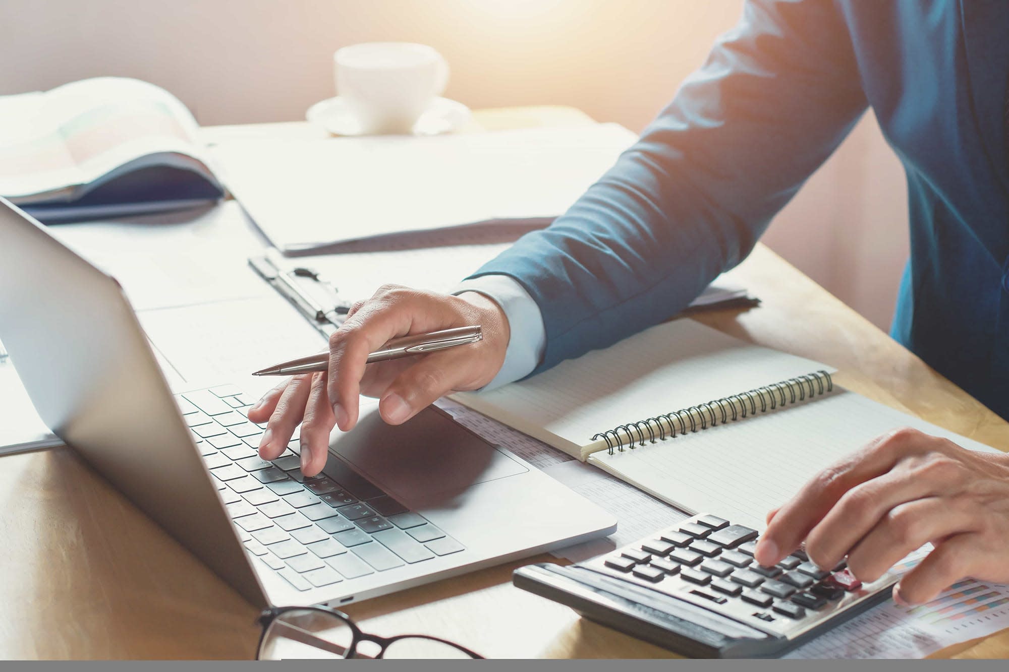 Man using computer with papers around him