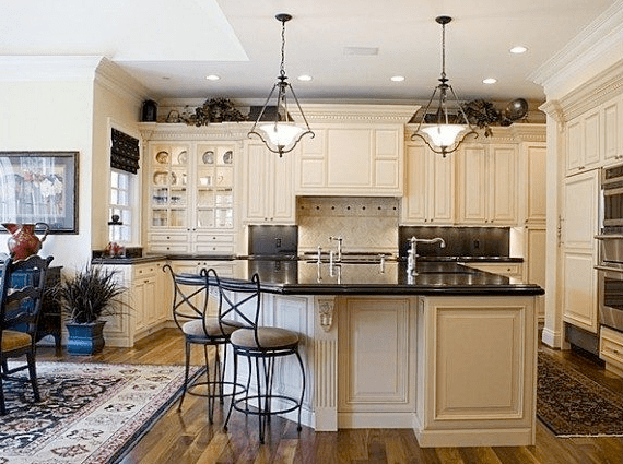 A kitchen view, dark countertops, light cabinets. 