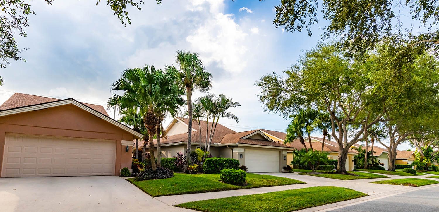Suburban neighborhood in Florida with one story homes and palm trees.