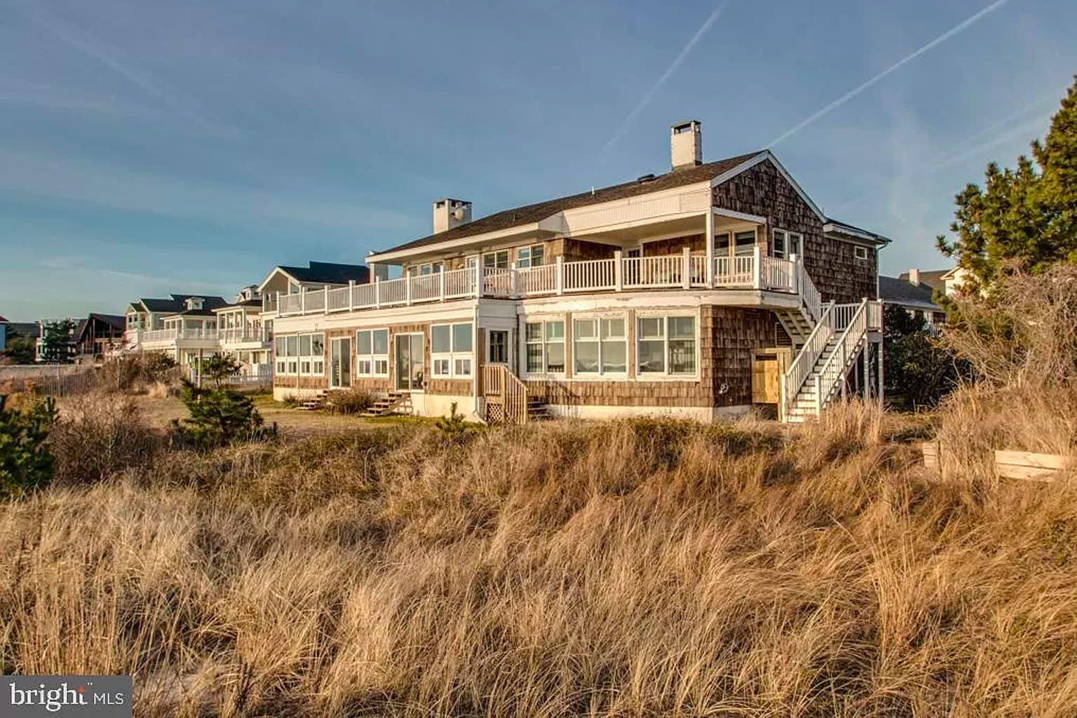 Brown beach house with a large deck. 