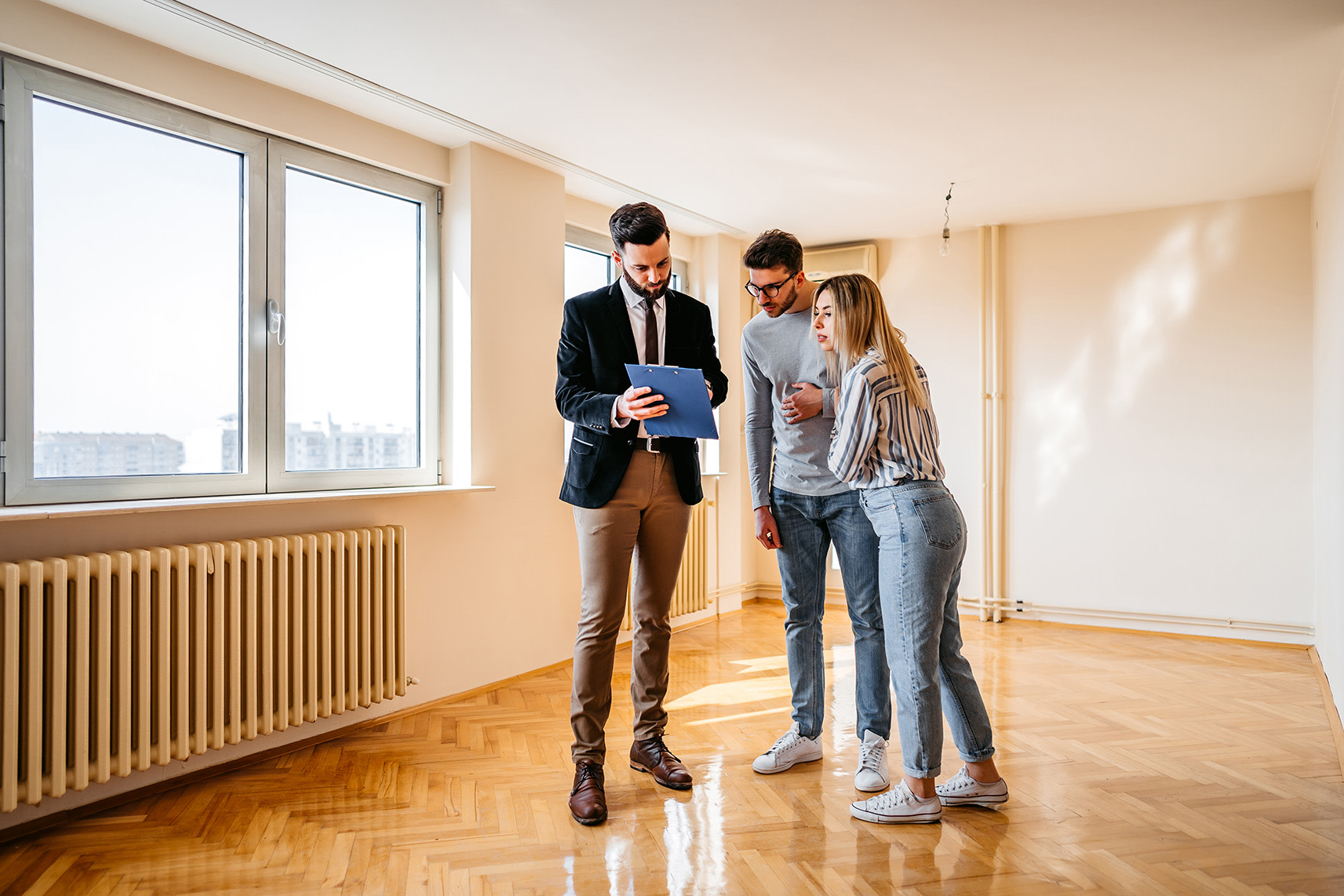 A man and woman looking at a man at his clipboard. 