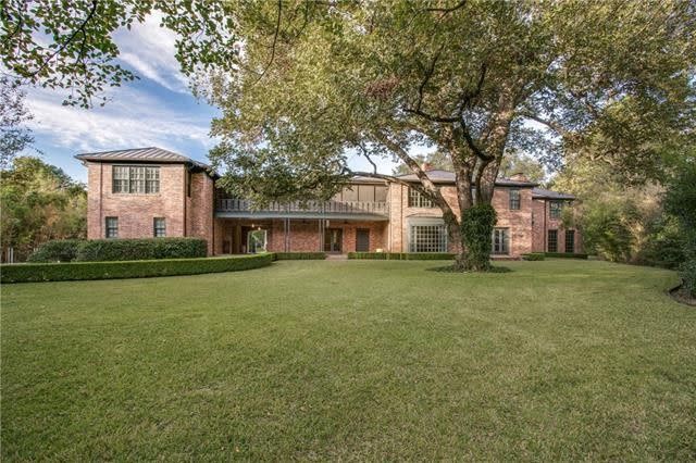 Light red brick houses with a large tree in the front yard. 