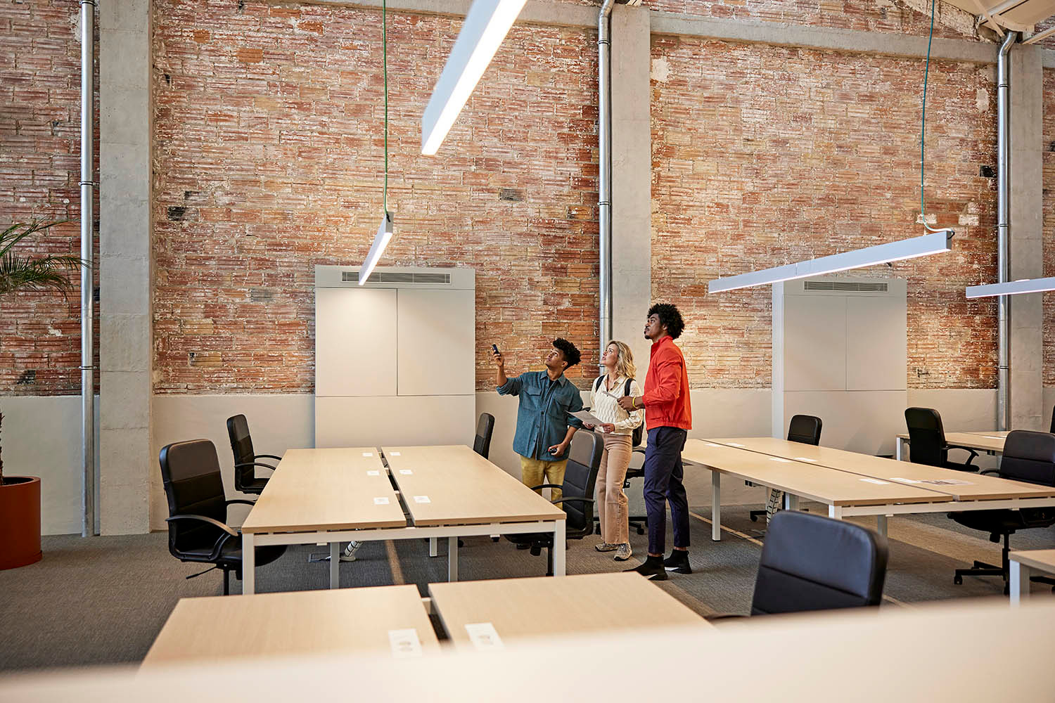 Three people looking up at something. 