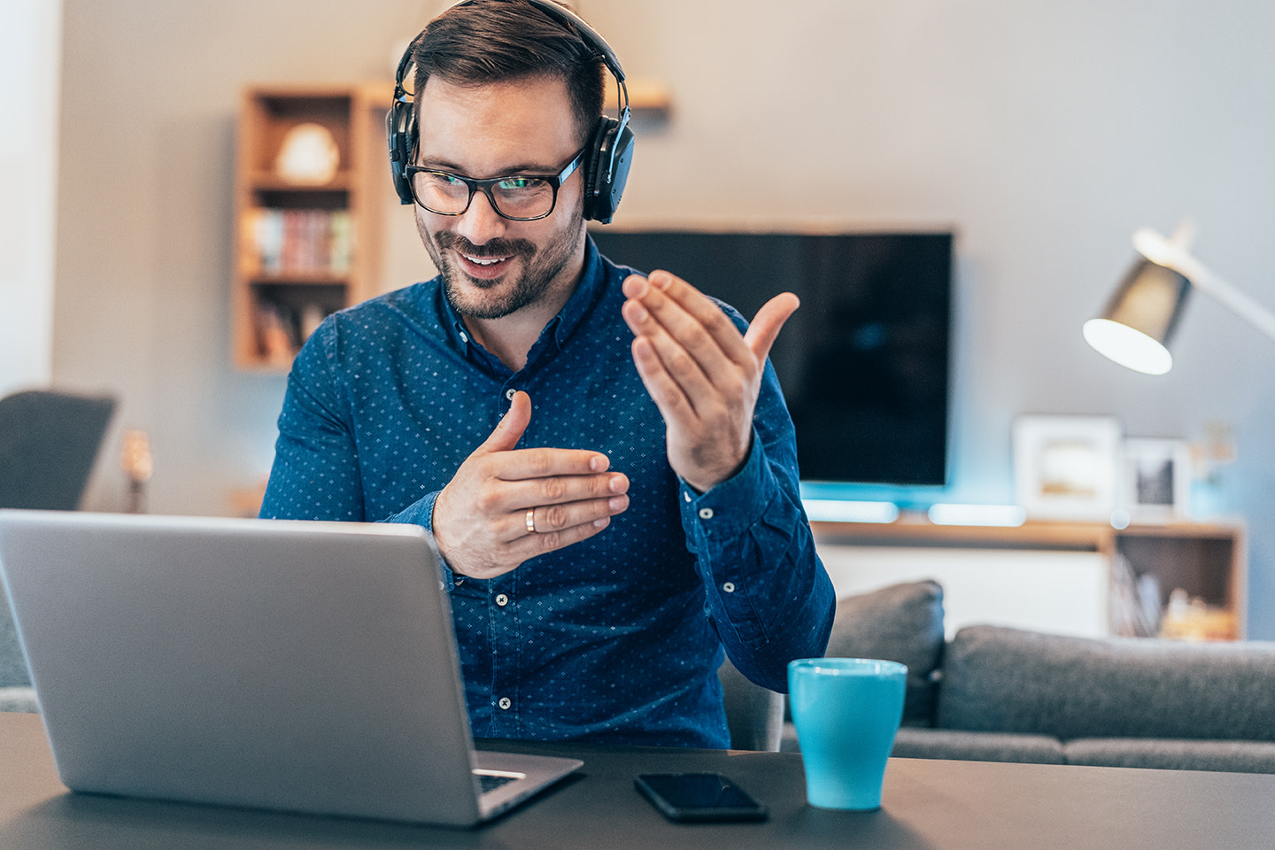 A man looking at a laptop and gesturing