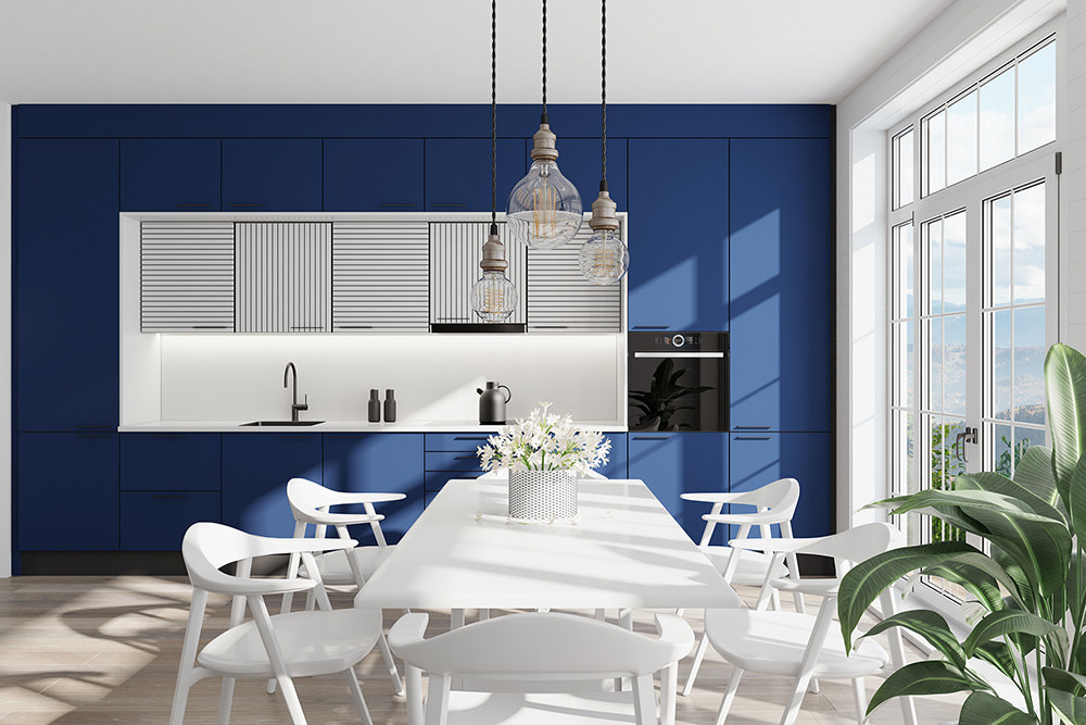 Coastal style kitchen with dark blue cabinets and a white table.