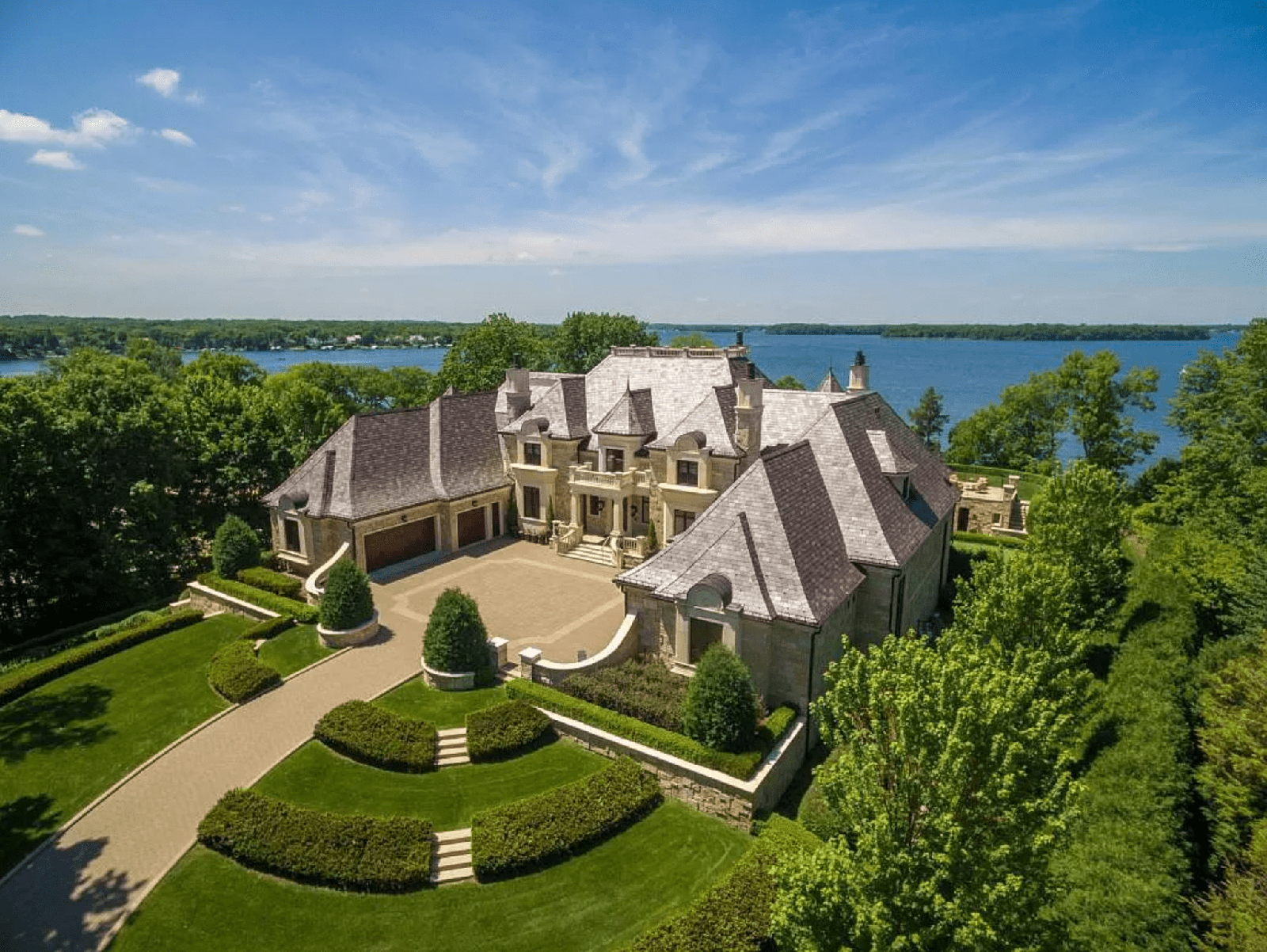 Sky view of a beautiful home sitting on a lake. 