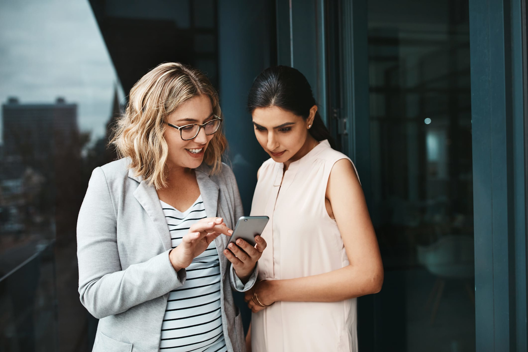 Two women on their phone outside