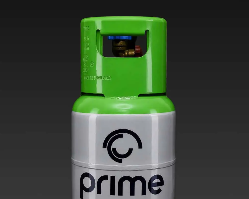 Green and silver gas cylinder with Prime branding and valve on top against dark background.