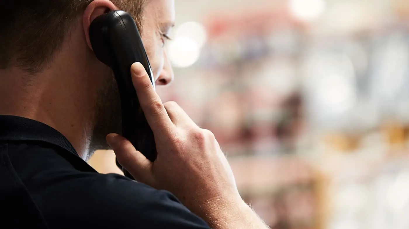 Person holding a phone to their ear during a phone call with a blurred background.