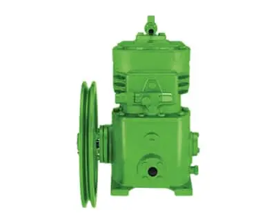 Green industrial open drive compressor on white background.