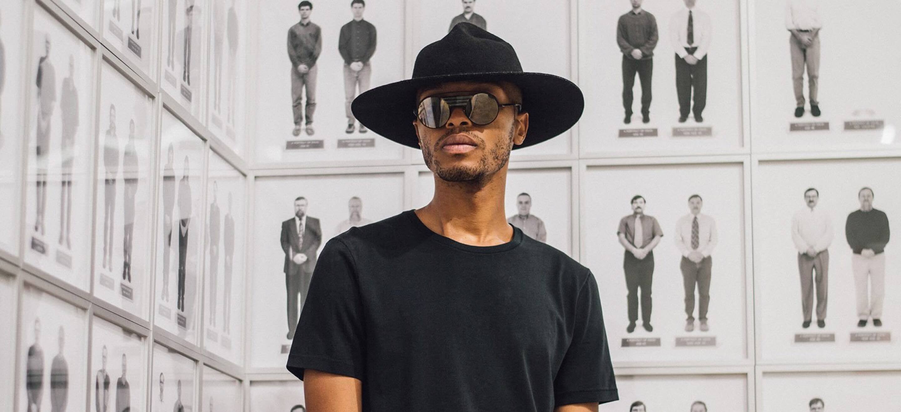 male model wearing black o n s t-shirt with sunglasses and hat