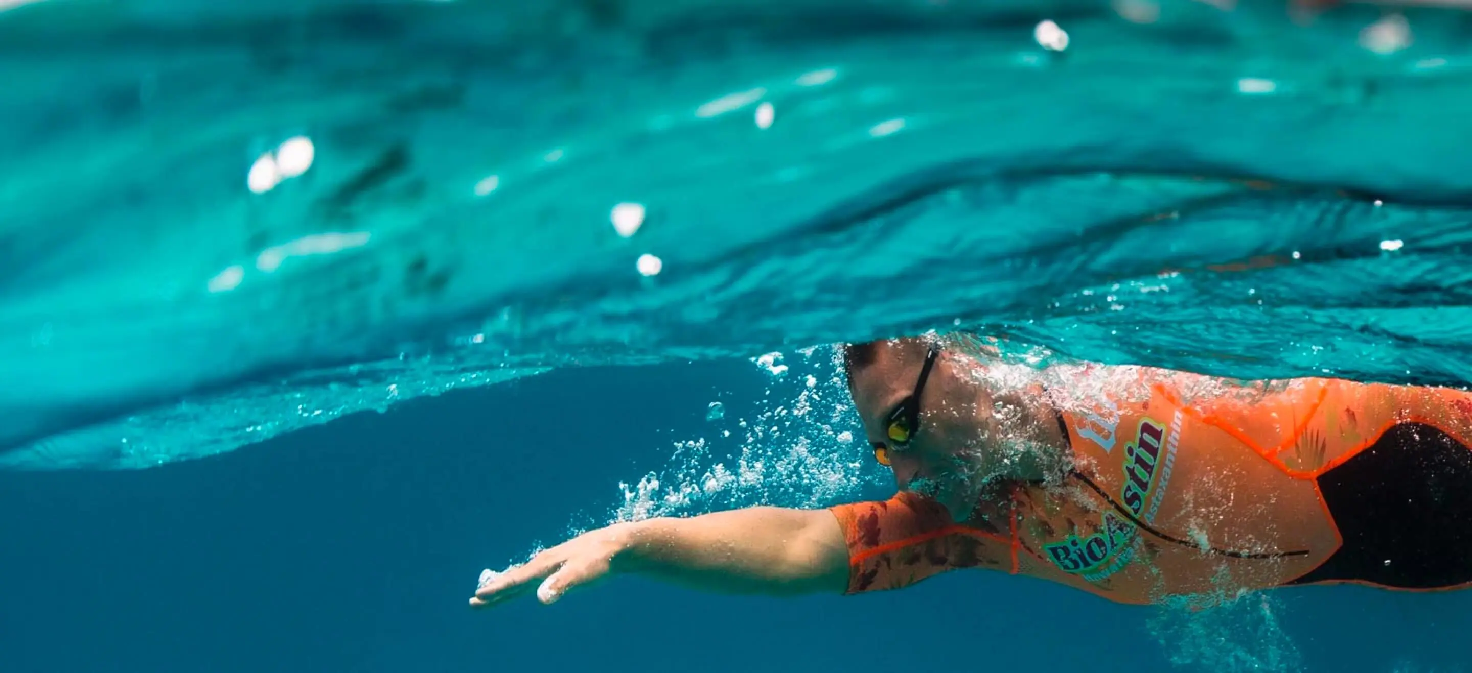 man swimming underwater in ocean