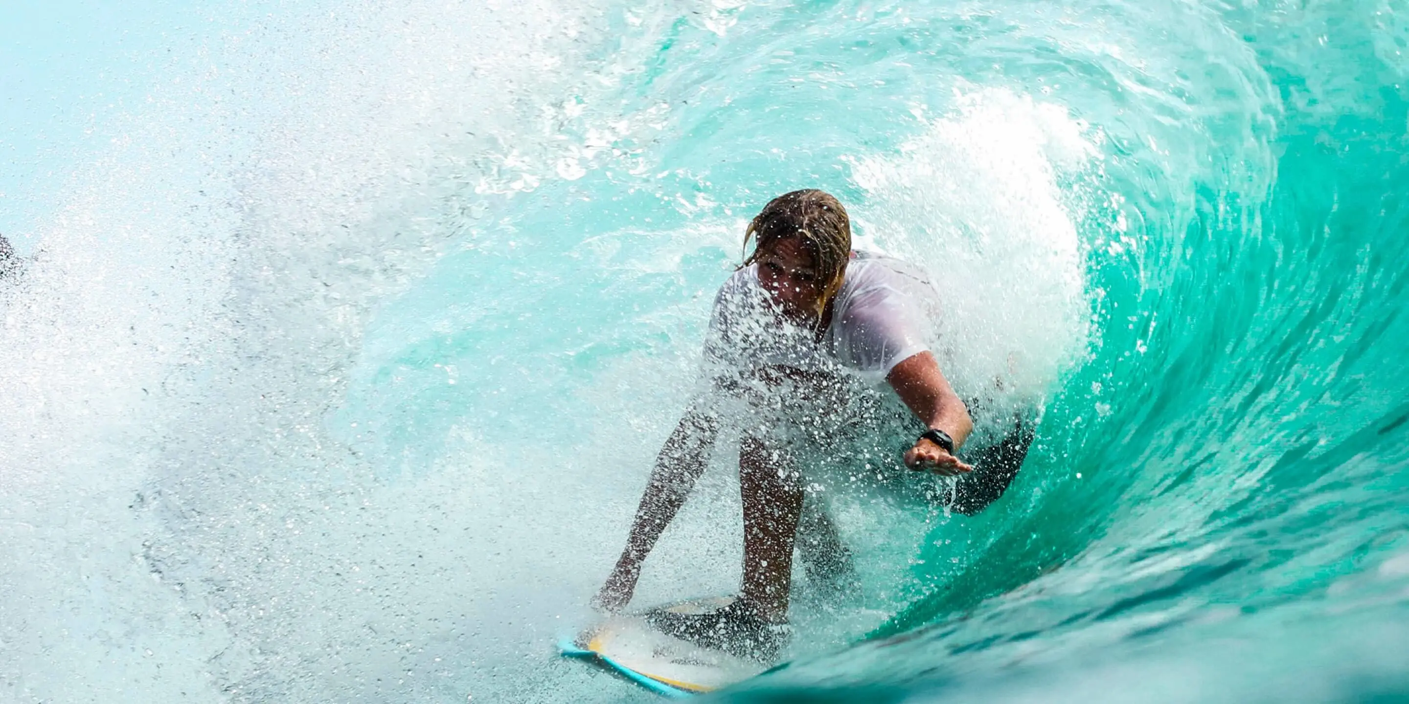 man shreds wave on surfboard
