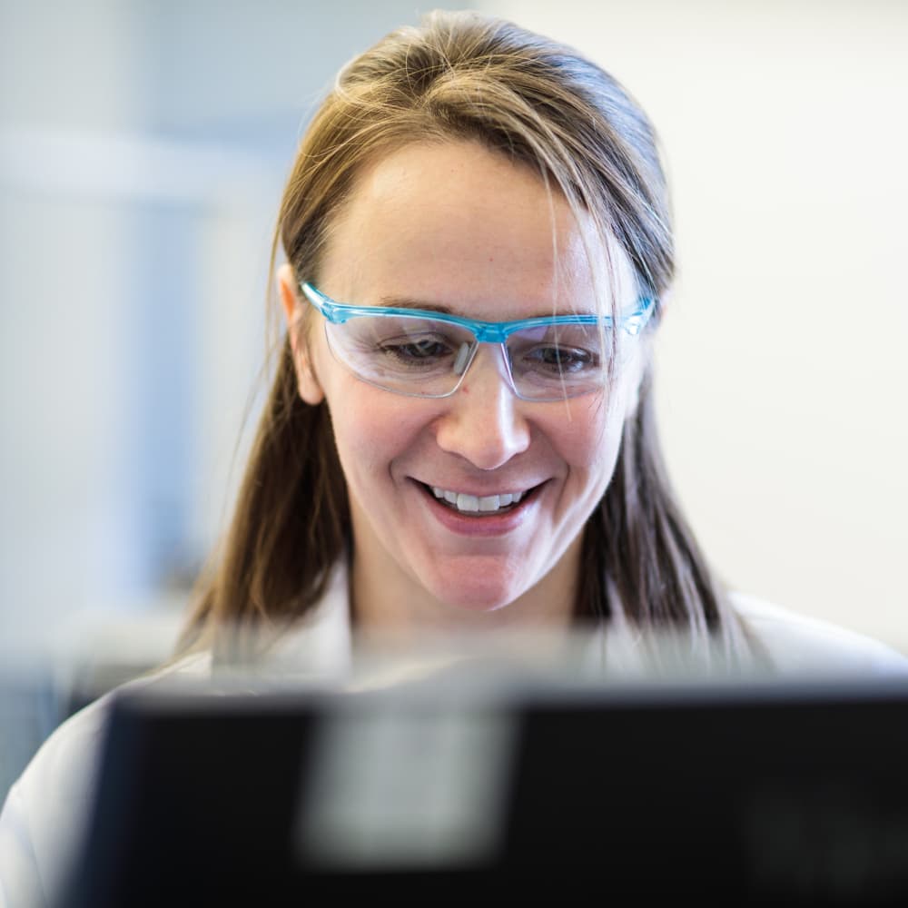 Female scientist smiling while working in a lab