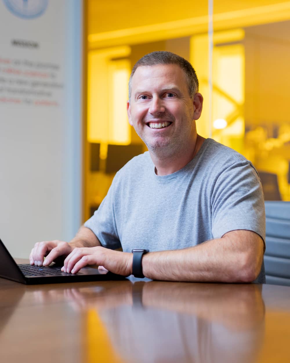 Man at desk working at computer smiling