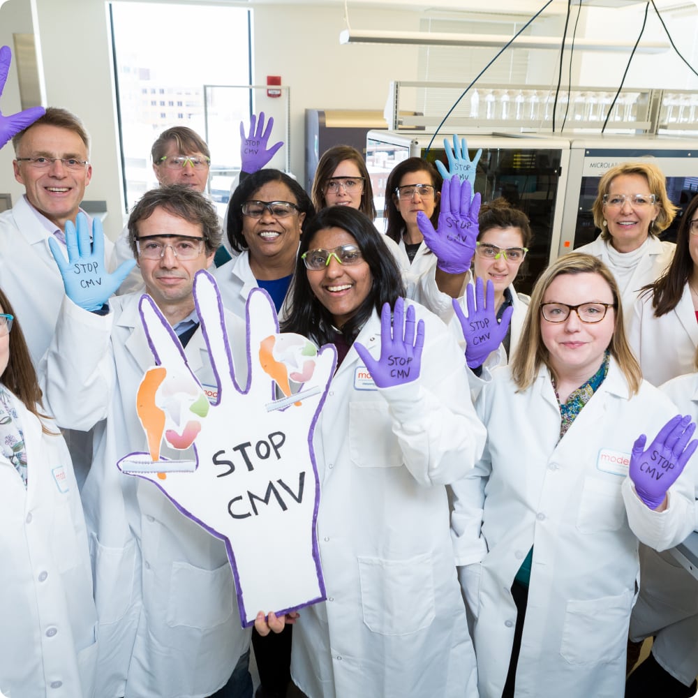 Group of scientists in lab gear holding up hands that say stop CMV