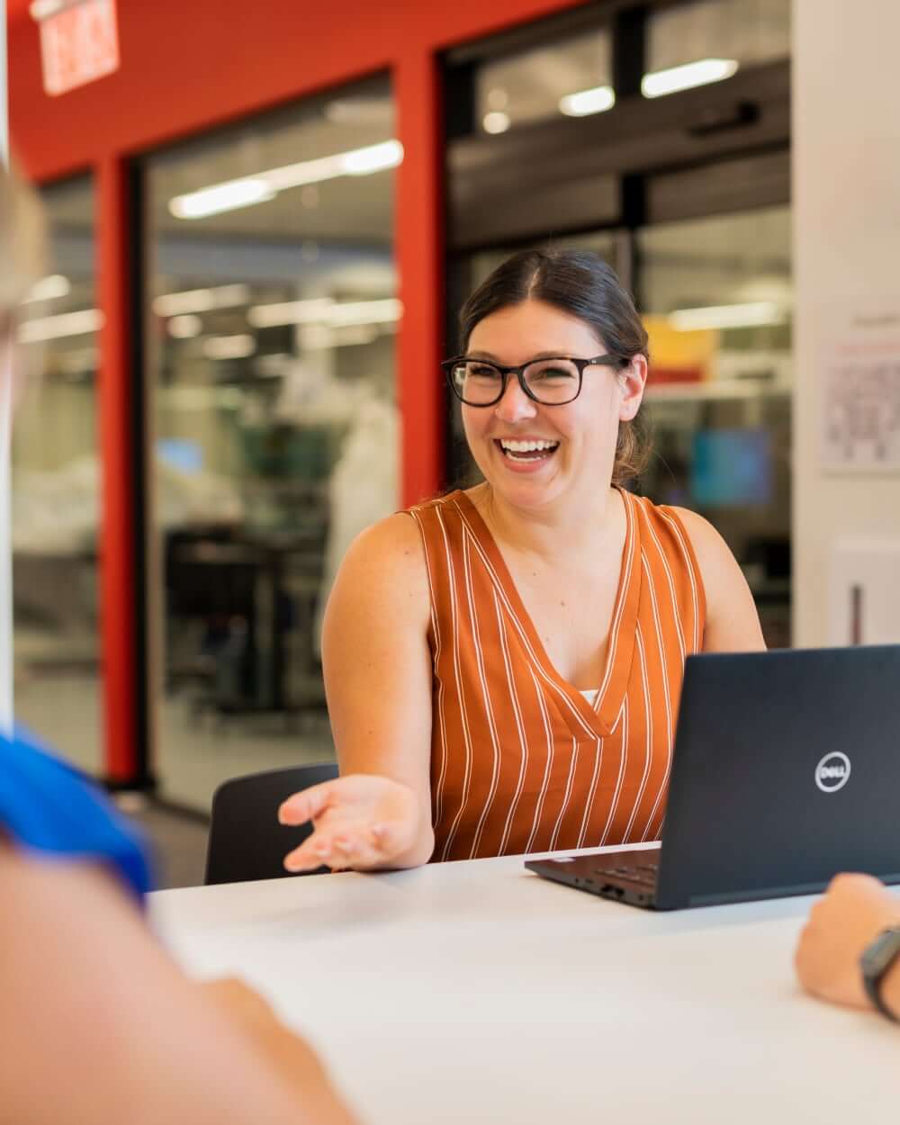 Woman smiling while on laptop at conference table