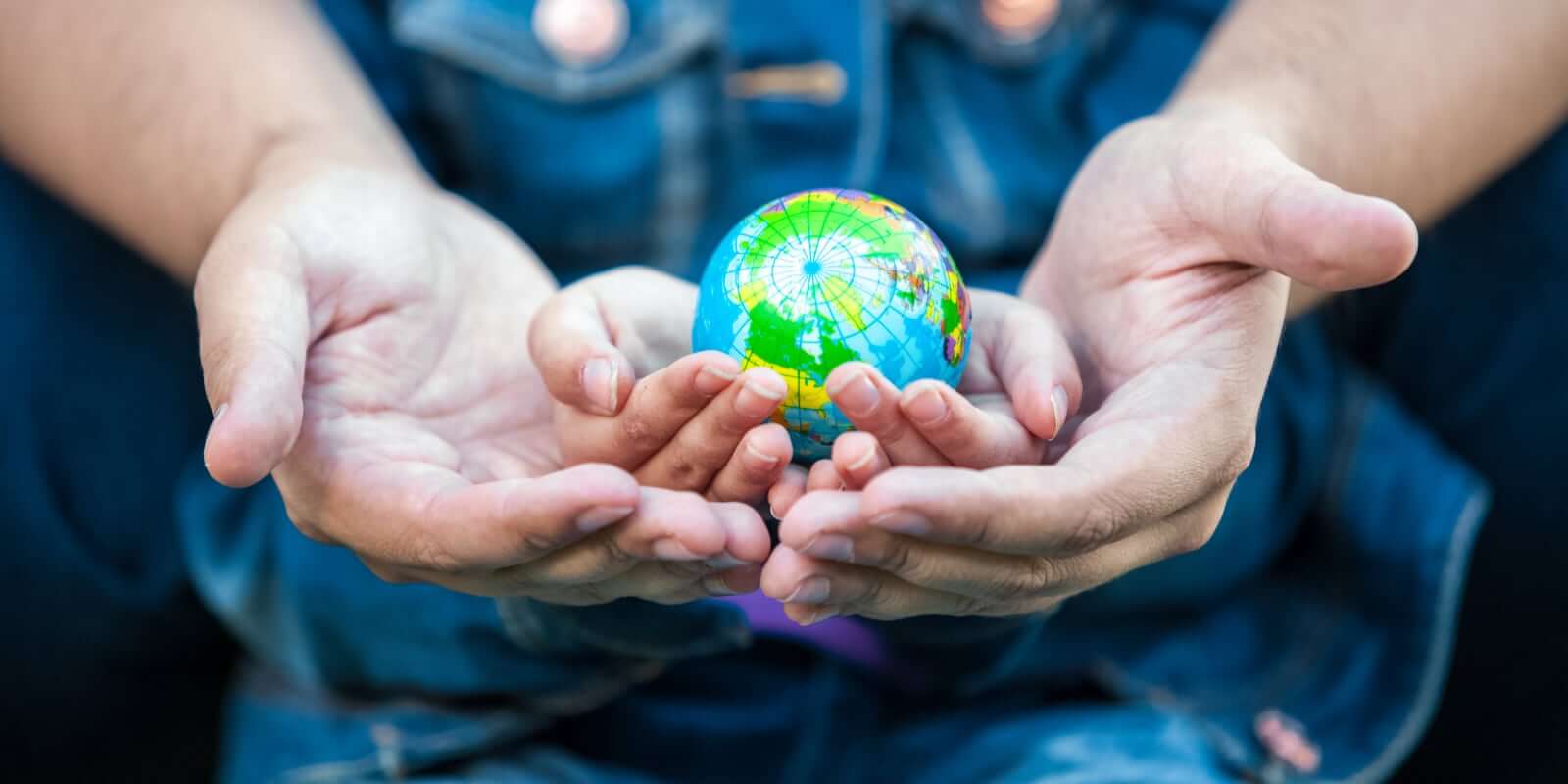 Adult and child hands holding globe