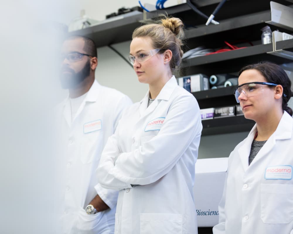 One male and two female scientists in a lab meeting