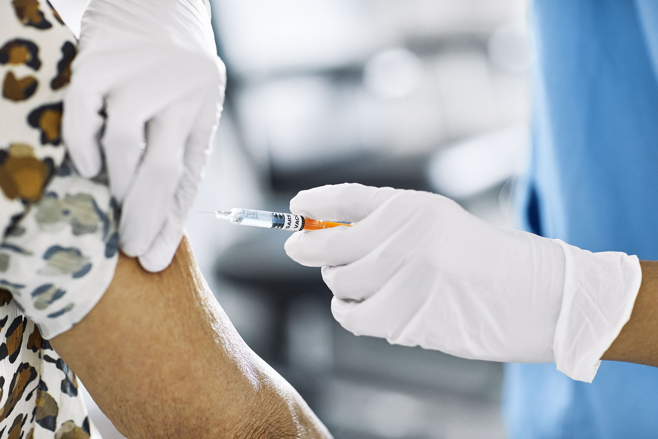 HCP using a syringe on a patient's arm