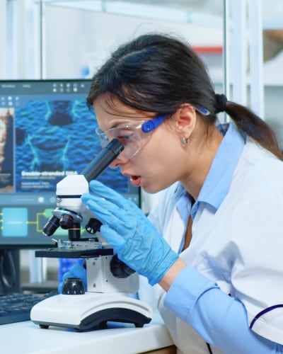 Scientist looking through microscope