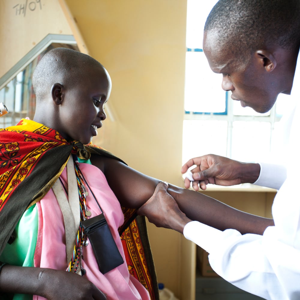 Doctor giving someone a vaccine in Africa