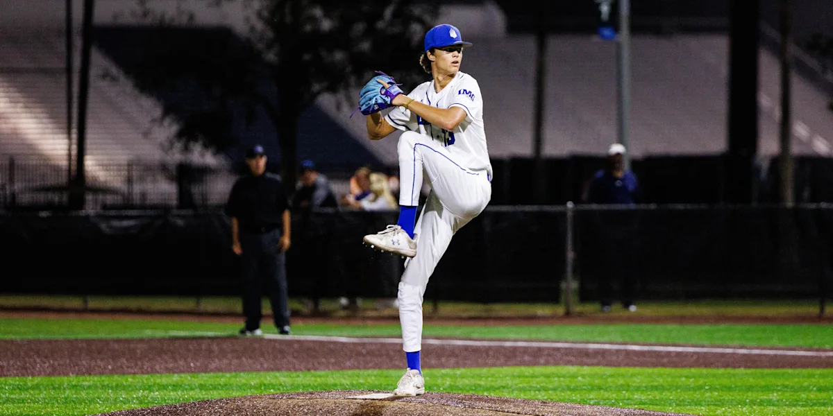 A baseball pitcher raises one knee during his delivery.