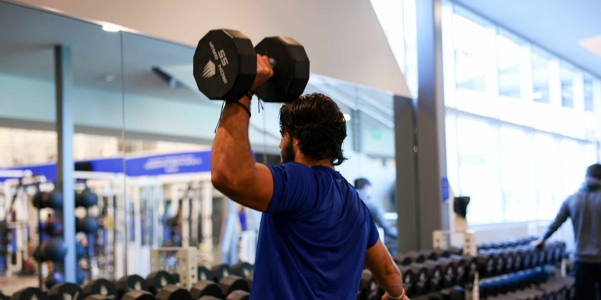 IMG Academy athlete uses left hand to shoulder press a dumbbell