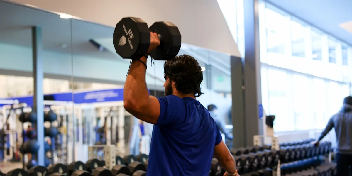 IMG Academy athlete uses left hand to shoulder press a dumbbell