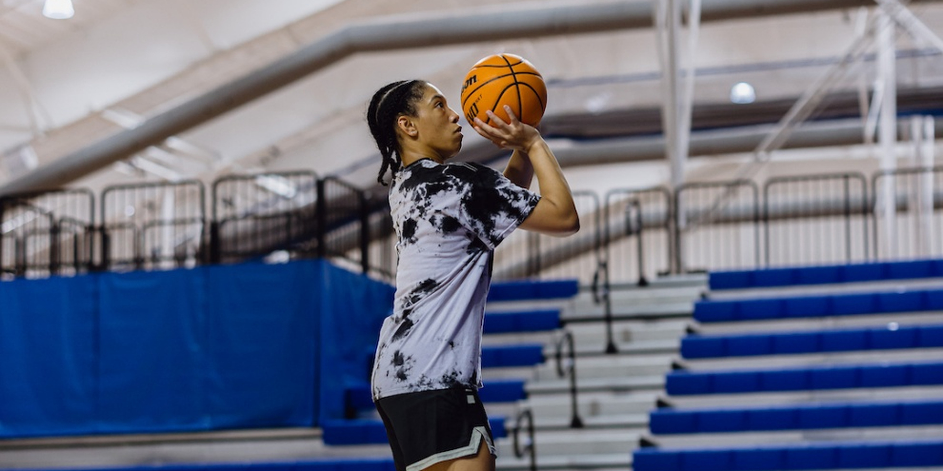 Student-athlete practices basketball shooting form on an indoor court at IMG Academy.
