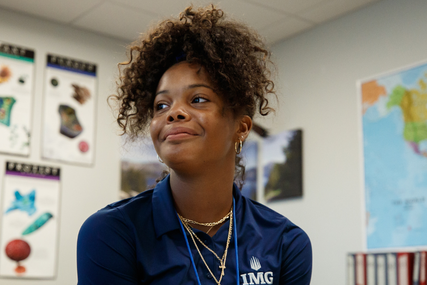 IMG Academy student sits in a classroom wearing a school uniform, representing academic excellence, student life, and a supportive learning environment.
